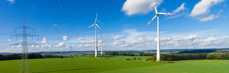 Wiesenlandschaft mit blauem Himmel und Windrädern