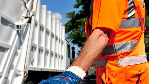 Arm eines Müllarbeiters und Müllwagen, jeweils im Anschnitt.